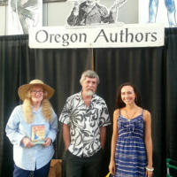 Francesca standing with two fellow authors in front of a banner that says Oregon Authors.