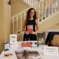 Francesca standing with her book, The Seas of Distant Stars, at the Courtyard Fountains Author Expo in Gresham, Oregon.